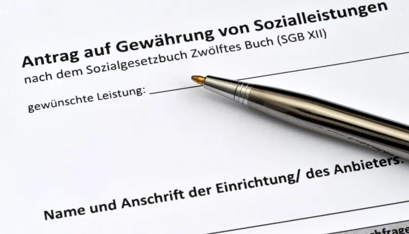 Antrag auf Sozialleistungen mit Stift. Viele Menschen teilen ihre sozialbetrug erfahrungen, wenn sie solche Formulare ausfüllen.