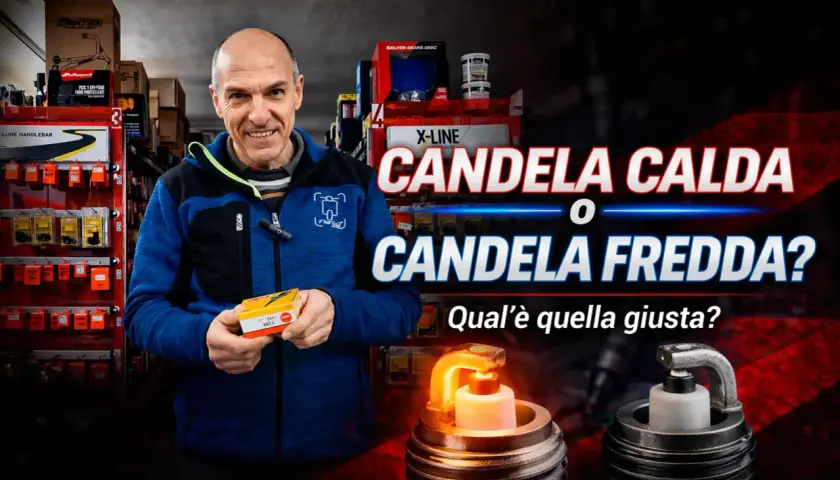Un uomo sorride in un negozio di ricambi, tenendo una scatola di candele. Davanti a lui, una candela calda e una fredda.