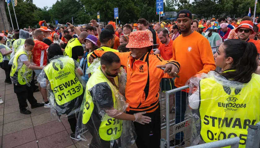 Ochrona sprawdza kibiców przed wejściem na stadion. Czy na stadion można wnieść jedzenie? Stewardzy w kamizelkach EURO2024 pilnują porządku.