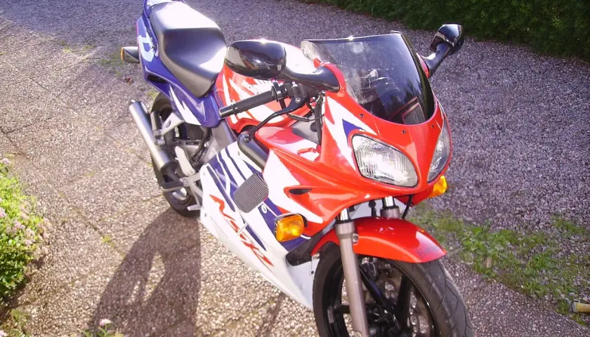 Sportowy motocykl Honda NSR 125 w czerwono-biało-niebieskich barwach, idealny do poznawania jego danych technicznych.