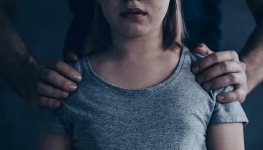Dziecko z rękami na ramionach. Czy socjopata kocha swoje dzieci? Pytanie pozostaje otwarte, gdy patrzymy na tę scenę.