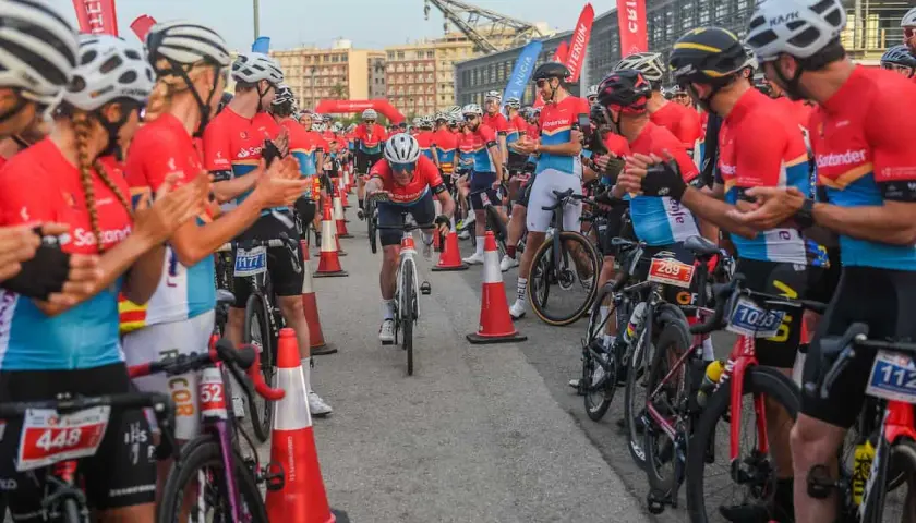 Ciclistas compiten en un gran fondo en Valencia. El público anima a los participantes mientras uno cruza la meta.