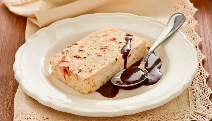 Delizioso semifreddo alla mandorla con salsa al cioccolato su un piatto bianco, pronto per essere gustato.