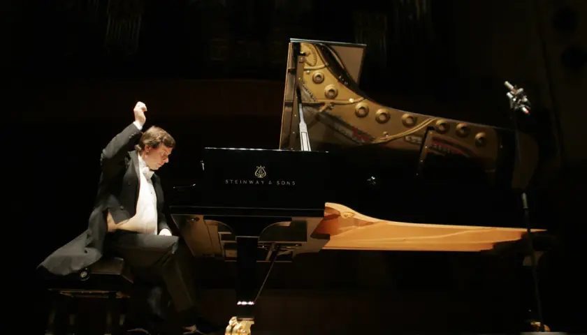 Krzysztof Jabłoński, pianista, w akcie tworzenia muzyki przy fortepianie Steinway. Data urodzenia artysty nie jest widoczna.