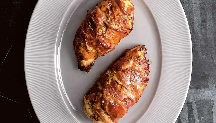 Två saftiga kycklingfiléer inslagna i bacon, perfekt tillagade i airfryer.