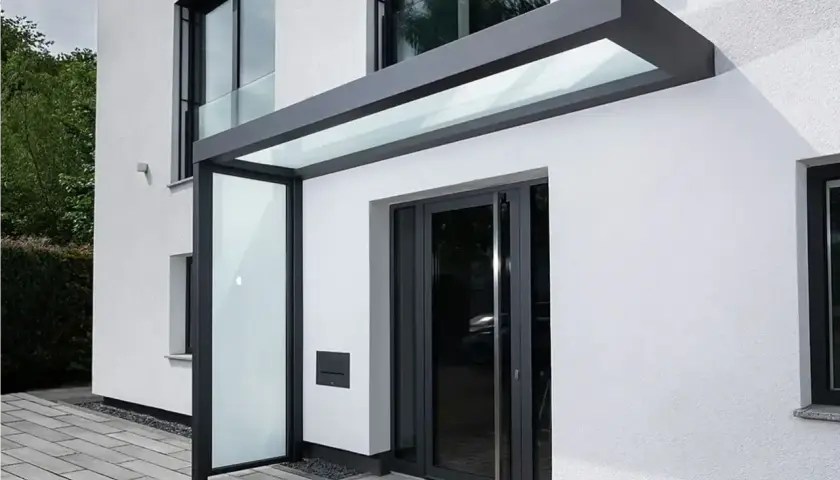 Moderne Ideen für ein Vordach am Hauseingang: Glas und Anthrazit schaffen einen eleganten Schutz.