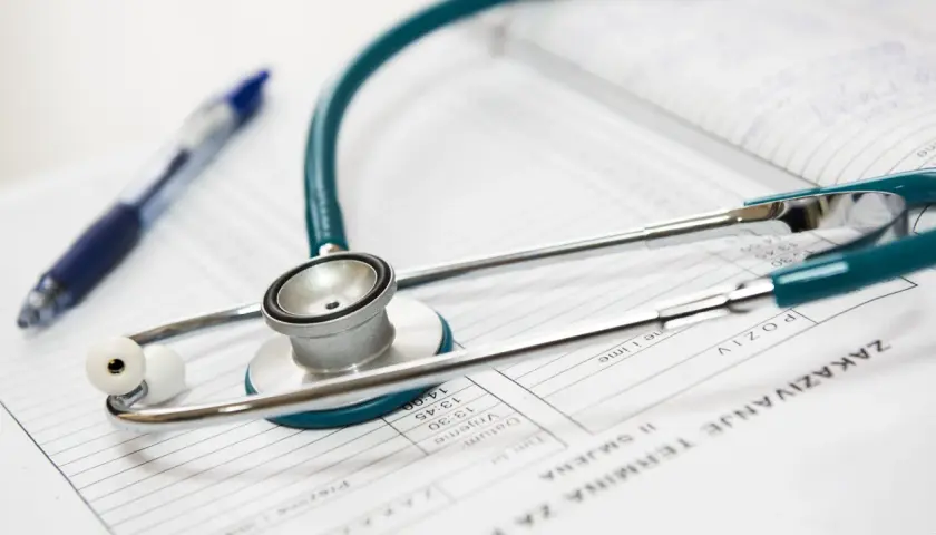 Stetoscopio e penna su foglio con appuntamenti, pronti per diagnosticare malattie in inglese.