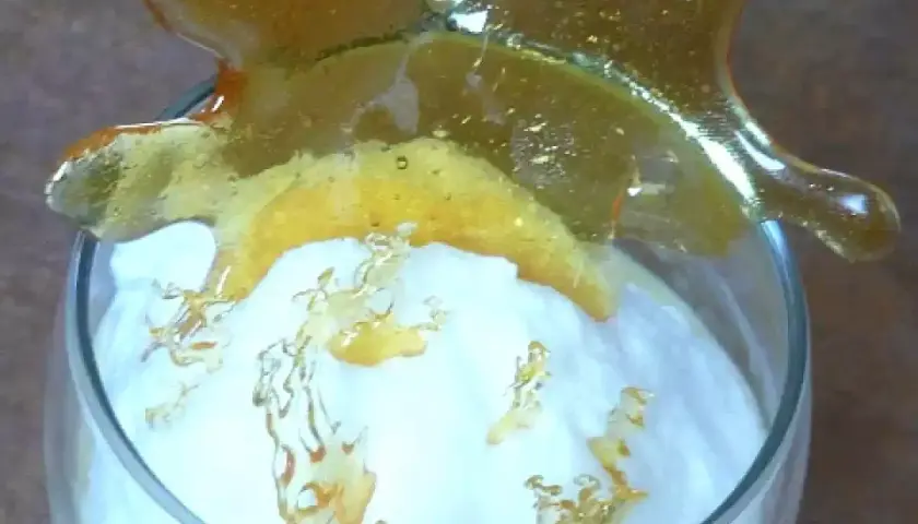 Un verre de crème aérienne surmonté d'une décoration en caramel craquant. Ces oeufs à la neige sont prêts à être dégustés.