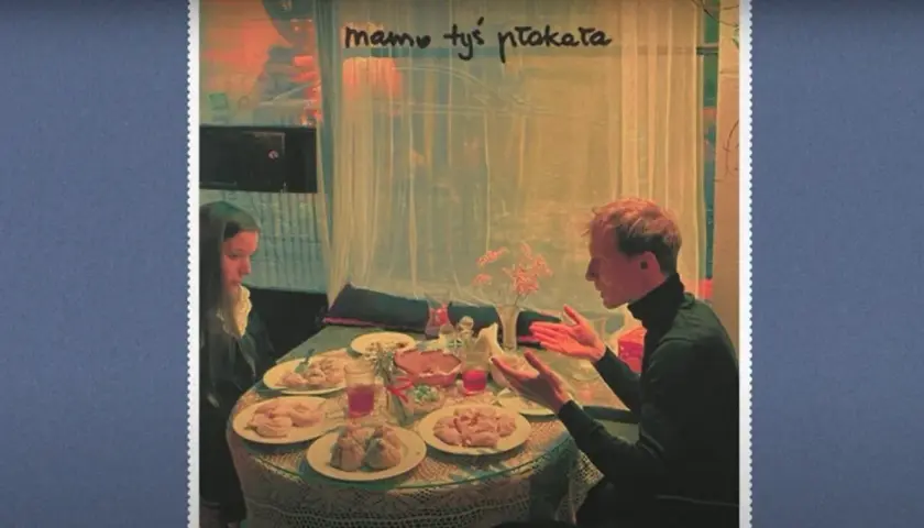 Sanah jako dziecko, siedzi przy stole z mężczyzną. Na stole jedzenie i napoje.