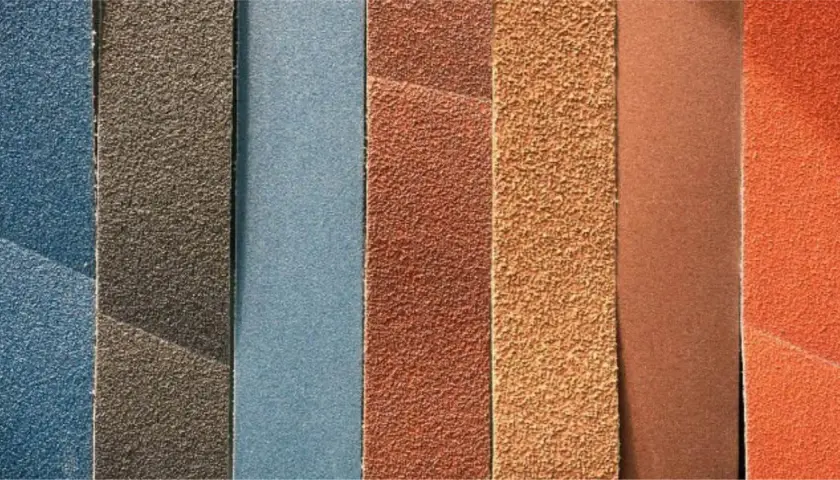 Bandes de grain papier à poncer de différentes couleurs et textures, prêtes pour le ponçage.