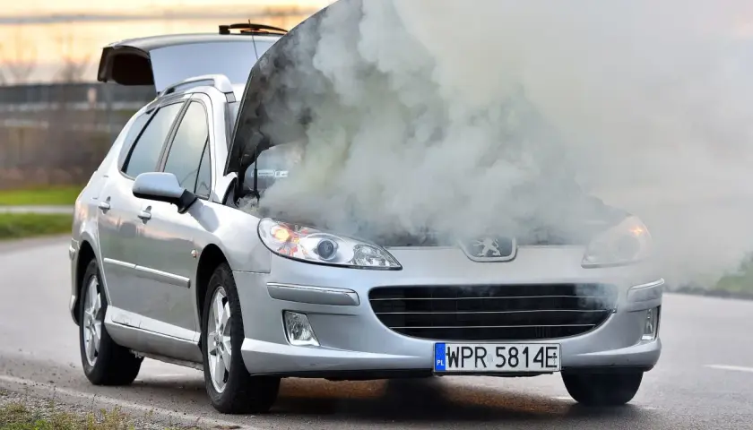 Srebrny Peugeot z otwartą maską, z której bucha dym. Rozbiegany silnik diesla dał o sobie znać w najgorszym momencie.