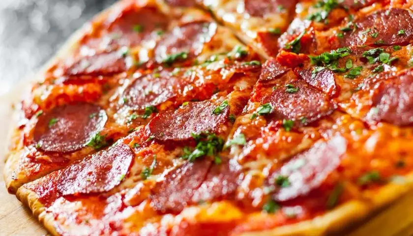 Pyszna pizza bez drożdży z pikantnym salami i posypką z ziół, idealna na szybki obiad.