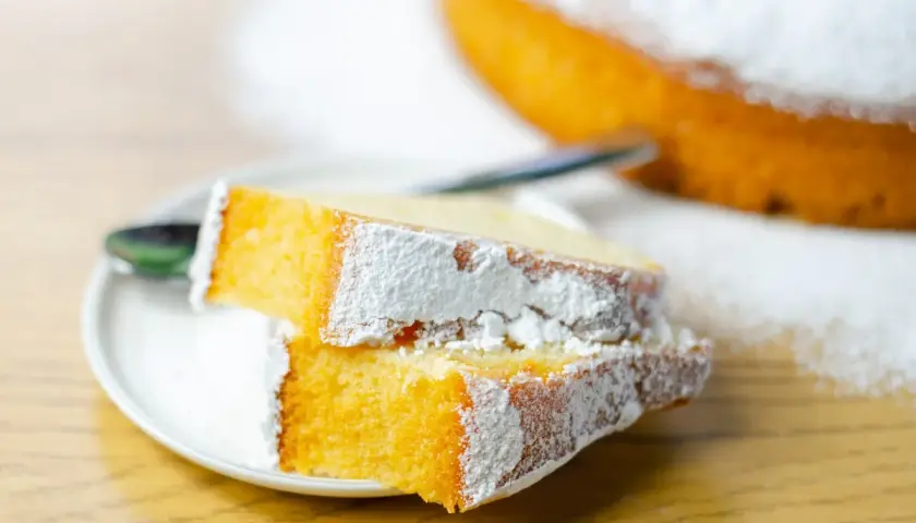 Due fette di torta soffice e dorata, spolverate di zucchero a velo, perfette per preparare torte golose facili.