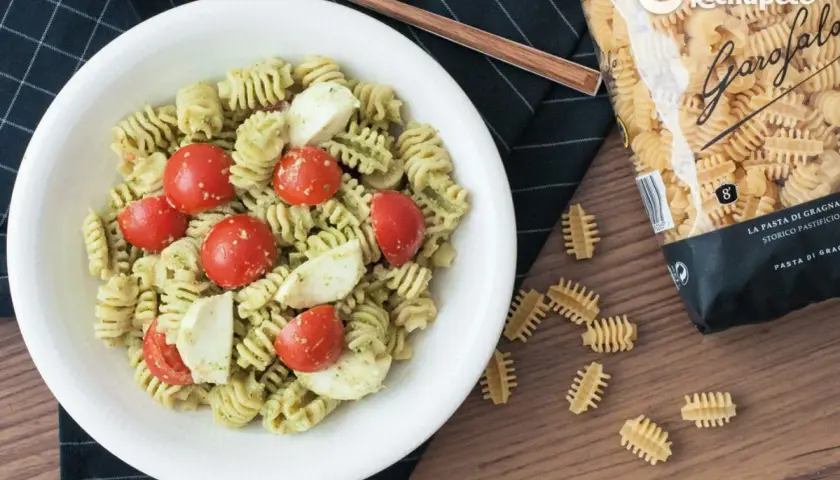 Ensalada de pasta al pesto con tomates cherry y mozzarella fresca. Un plato ligero y delicioso.