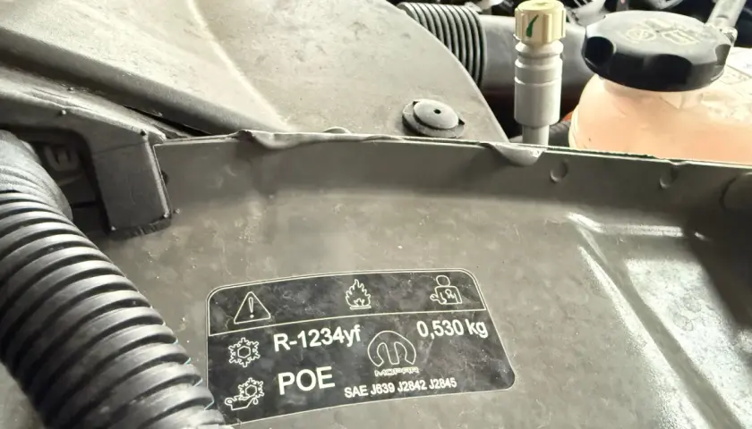 Naklejka pod maską informuje o czynniku chłodniczym R-1234yf, oleju POE i jego ilości 0,530 kg, zgodnie z normami SAE J639, J2842, J2845.