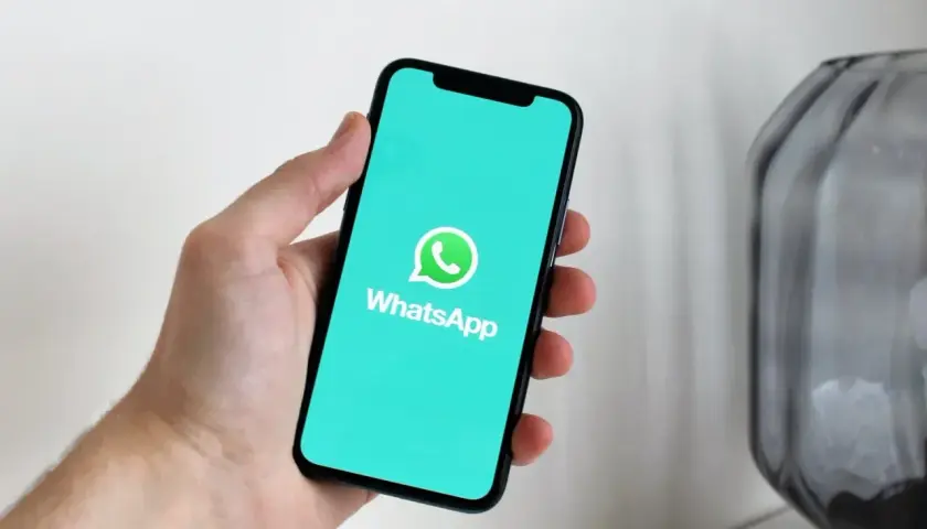 Dłoń trzyma smartfon z logo WhatsApp. Aplikacja istnieje od 2009 roku, więc ma już swoje lata!
