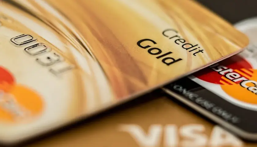 Cartes de crédit dorées, dont une "Gold", superposées. Pensez aux frais bancaires au Portugal pour ces paiements.