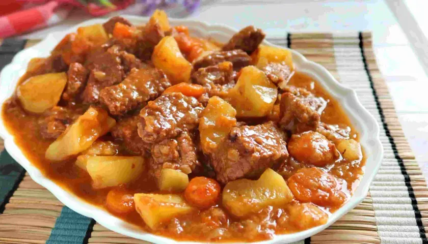 Un plato humeante de estofado de ternera con patatas y zanahorias en una salsa rica y sabrosa.