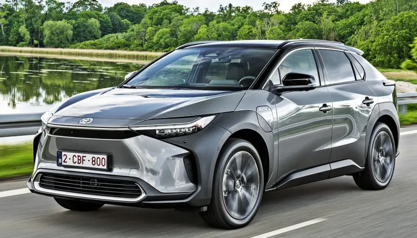 Szary Toyota bz4x cena jest atrakcyjna, gdy jedzie nad jeziorem.