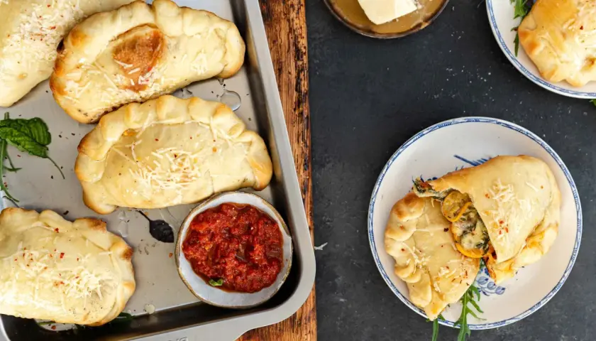 Mini calzone przepis: złociste, pieczone pierożki z serem i ziołami, podane z sosem pomidorowym. Idealne na przekąskę.