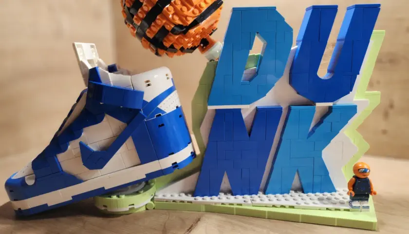 Lego-Nachbau eines Nike Dunk Sneakers mit Basketball und dem Wort "DUNK" aus bunten Lego-Steinen.