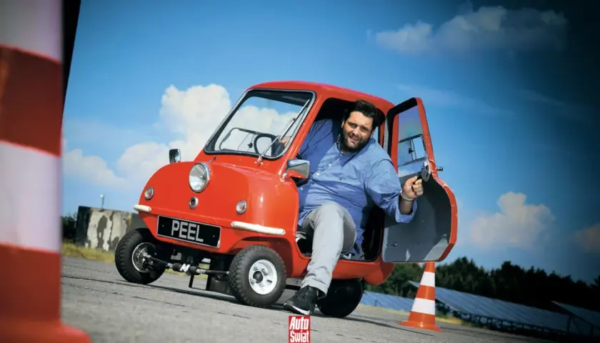Uśmiechnięty mężczyzna w czerwonym Peel P50. Czy to najtańszy samochód świata?