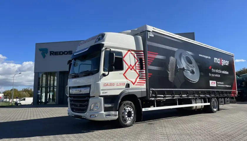 Biała ciężarówka DAF z naczepą reklamującą części samochodowe Maxgear. Długość tej ciężarówki to ok. 13,6 metra.