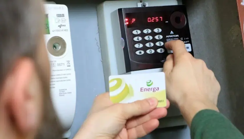 Doładowanie licznika przedpłatowego Energa. Osoba wprowadza kod na klawiaturze urządzenia.