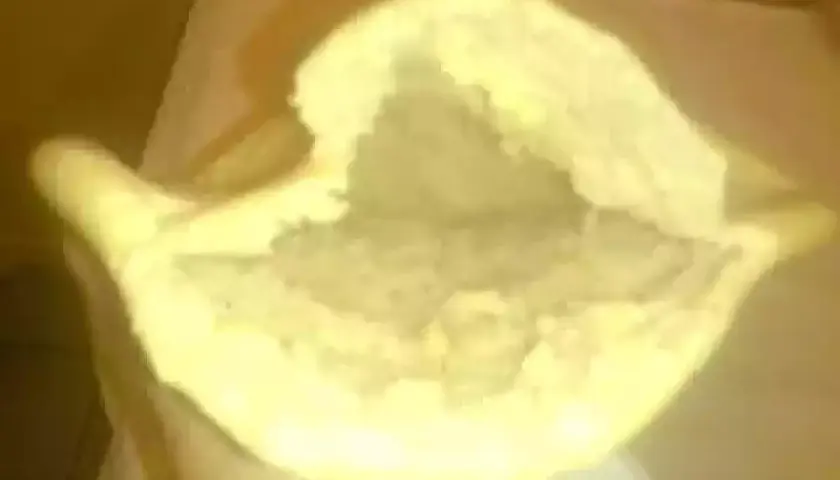 Une main tient un pain libanais ouvert, prêt à être garni. Sa texture moelleuse et sa poche invitent à la gourmandise.