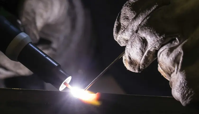 Un soldador usa una antorcha para crear una chispa brillante, demostrando que es la soldadura.