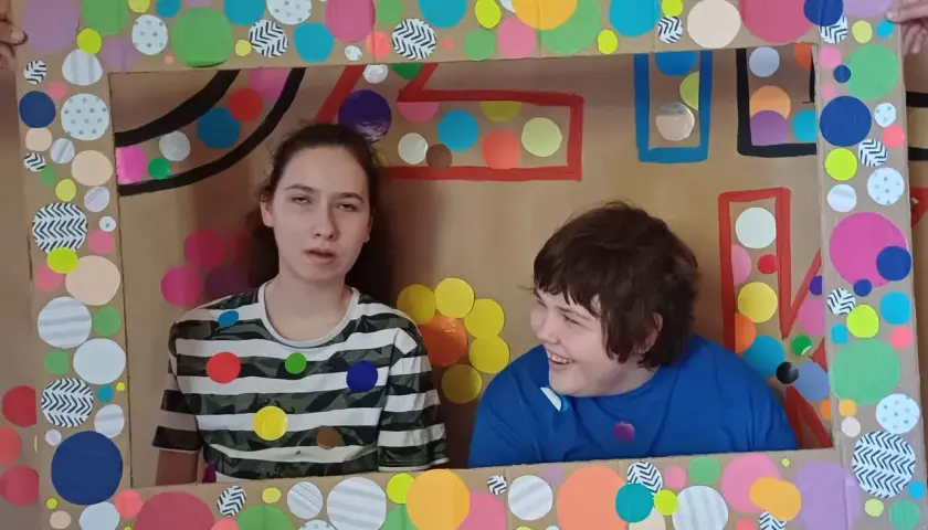 Dwie dziewczynki w ramie z kolorowych kółek.