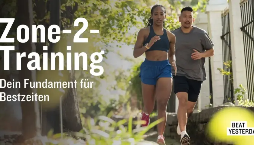 Ein Mann und eine Frau laufen im Freien. Der Text "Zone-2-Training" und "Dein Fundament für Bestzeiten" ist prominent platziert.