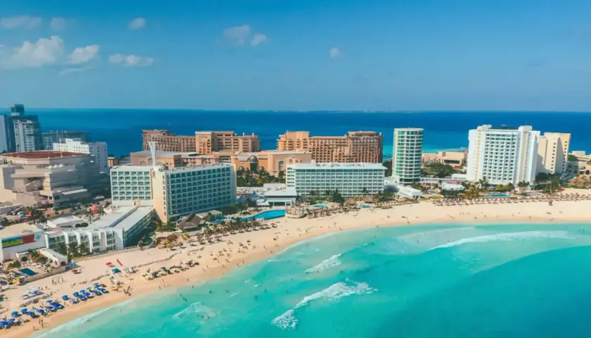 Traumhafter Strand in Mexiko, Cancun. Türkises Meer, weiße Hotels und Palmen säumen die Küste.