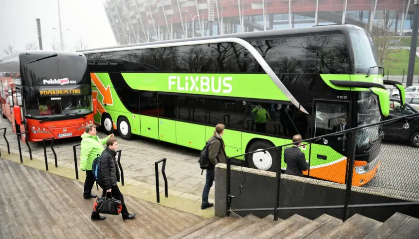 Dwa autokary Flixbus i PolskiBus stoją obok siebie.