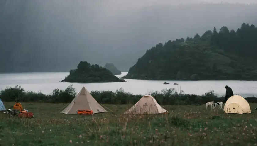 Namiotowe miasteczko nad jeziorem, mgliste góry w tle. Idealne miejsce na samotny wyjazd Polska.