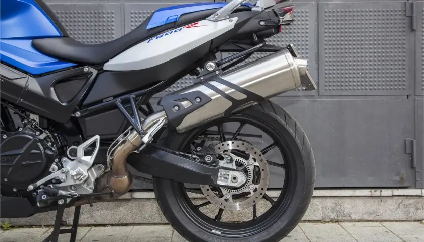Detalle de la BMW F800R, ideal para quienes buscan opiniones sobre esta moto. Destaca su asiento bicolor y escape cromado.