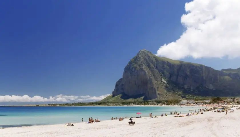 Spiaggia di San Vito Lo Capo, un vero paradiso di **Palermo mare senza auto**. Acque cristalline, sabbia bianca e la maestosa montagna di Monte Monaco.