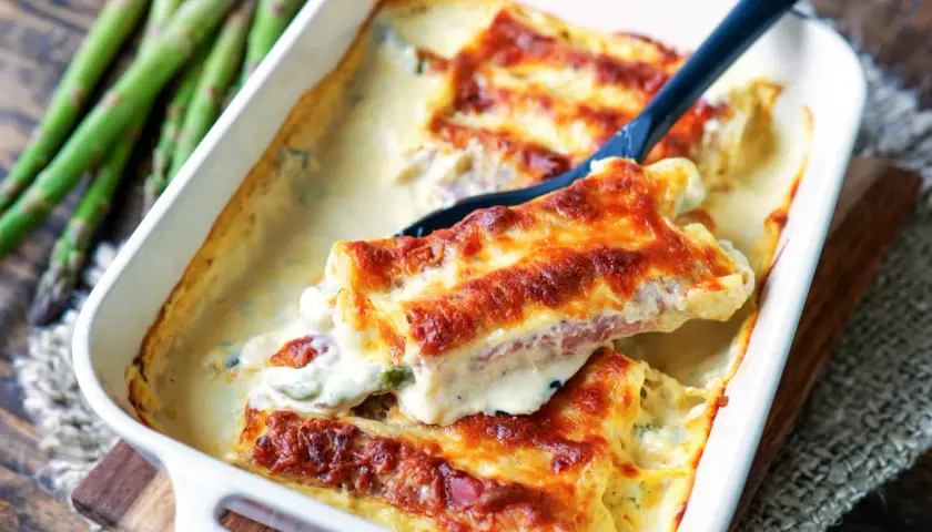 Überbackene Cannelloni mit Spargel und Schinken, ein köstliches Cannelloni Rezept, das in einer Auflaufform serviert wird.
