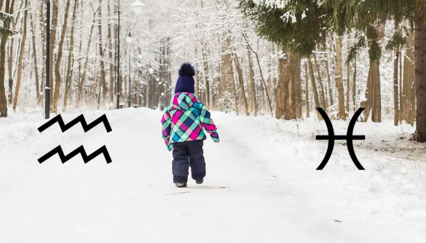 Dziecko w zimowym parku, obok symbole Wodnika i Ryb, sugerujące luty znak zodiaku.