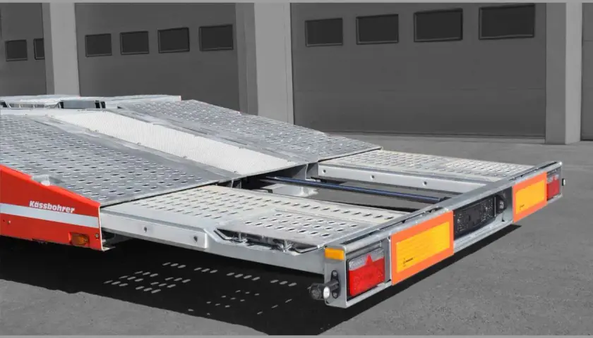 Ein roter Kässbohrer Autotransporter mit ausziehbarer Ladefläche, bereit für den Transport.