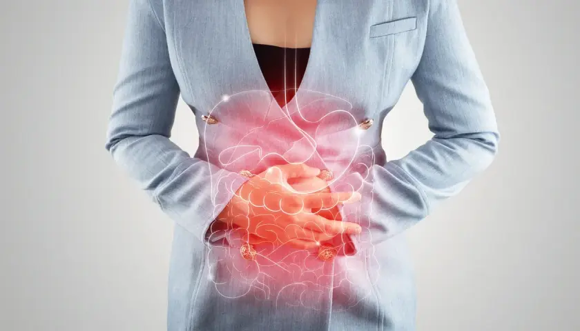Frau hält sich den schmerzenden Bauch, rote Darstellung des Verdauungstrakts. Mögliche bauchfellentzündung symptome.