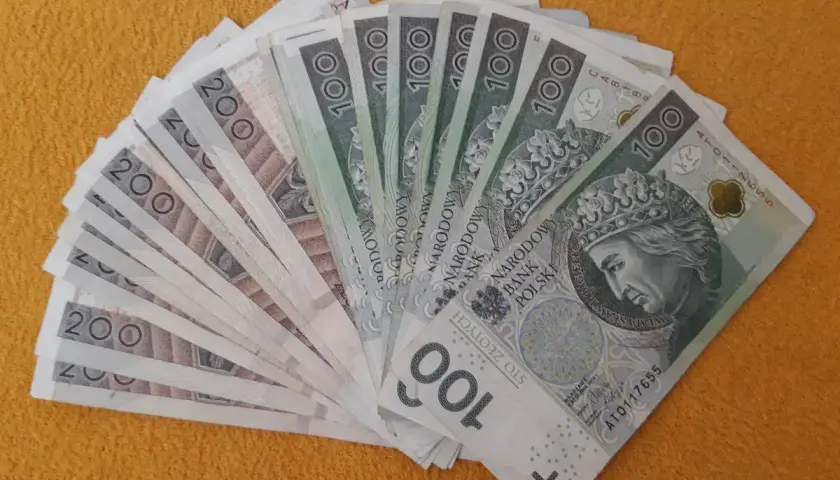 Stos banknotów 100 i 200 zł, miły gest - darowizna od brata.