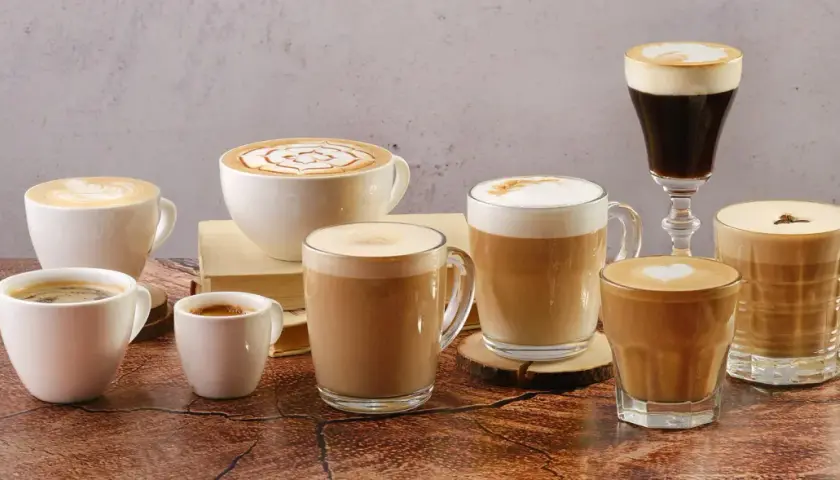 Vielfalt an Kaffee Kreationen: Latte Art, Espresso und cremige Cappuccinos in verschiedenen Tassen und Gläsern.