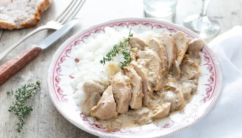 Délicieuse recette filet de poulet à la crème et champignons, servi avec du riz blanc et garni de thym frais.