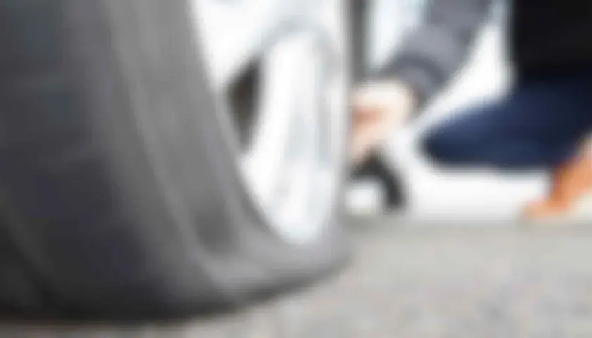 Person använder punkteringsspray för att laga ett platt däck.