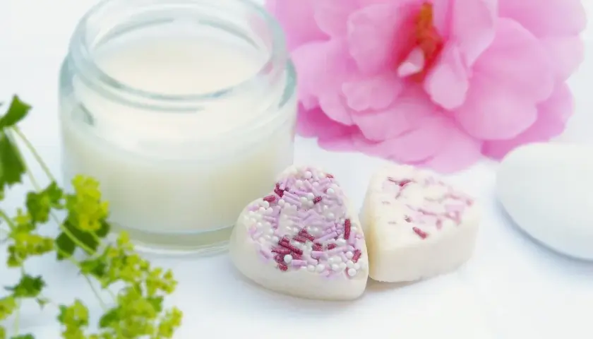 Słoiczek z kremem, serduszka z posypką i różowa piwonia. Krem zawiera caprylic capric triglyceride, składnik nawilżający.