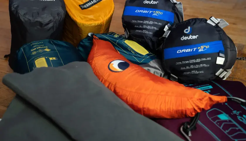 Śpiwory Deuter, karimata Thermarest i pomarańczowa poduszka – to wszystko, co zabrać pod namiot na nocleg w plenerze.