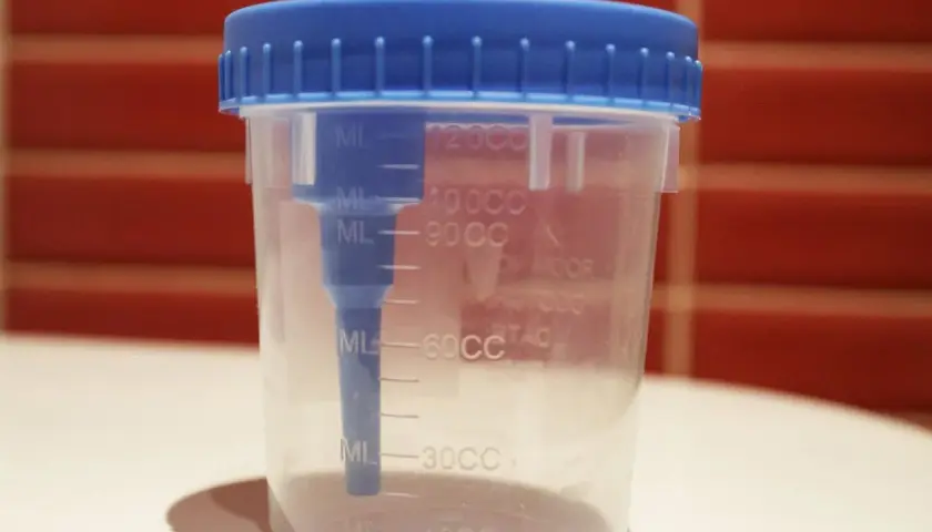 Contenitore sterile con tappo blu per la raccolta urine neonato, graduato per misurare il volume.