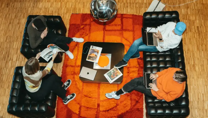 Fyra personer jobbar på sina laptops i en kreativ miljö i Stockholm. En glittrig discokula hänger ovanför.