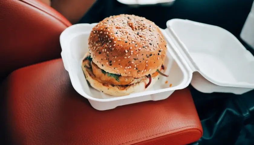 Pyszny burger w białym pudełku, idealny na szybki posiłek w podróży. Nie martw się o wieśmac kcal, ciesz się smakiem!